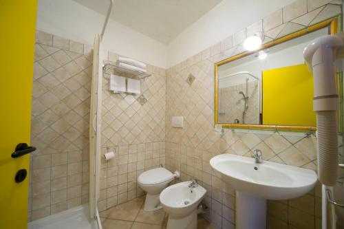 a bathroom with a sink and a toilet and a mirror at Chalet Della Guida in Bardonecchia