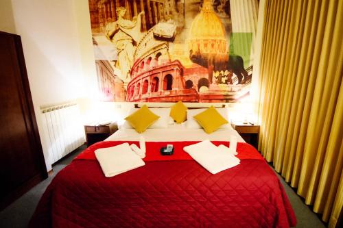 Hotel Palombella & Restaurant في فروزينوني: غرفة نوم بسرير كبير مع بطانية حمراء ومخدات صفراء