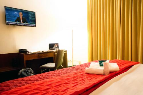 a hotel room with a bed and a desk and a computer at Hotel Palombella & Restaurant in Frosinone