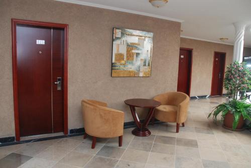a lobby with two chairs and a table and a door at Wassamar Hotel in Addis Ababa