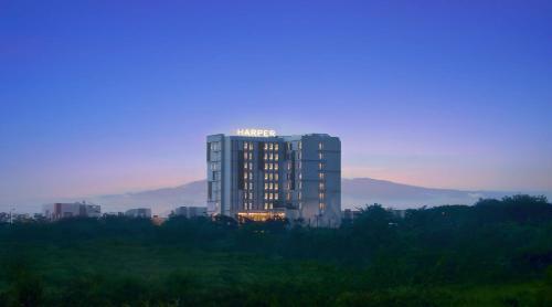 ein hohes Gebäude mit Lichtern darauf in der Unterkunft Harper Cikarang by ASTON in Cikarang
