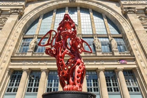 a red sculpture in front of a building at Hôtel Paris Nord in Paris