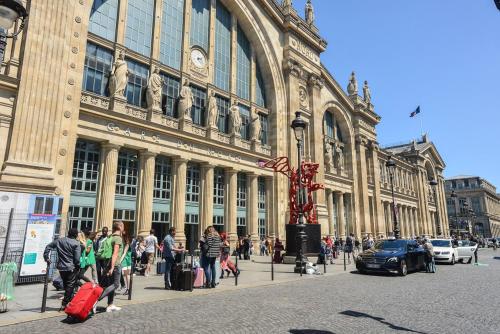 a group of people walking in front of a building at Hôtel Paris Nord in Paris