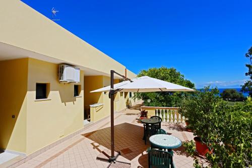 a patio with a table and an umbrella at Residence New Paradise in Tropea