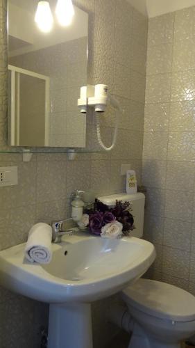 a bathroom with a sink and a toilet and a mirror at Affittacamere Museo in Taranto