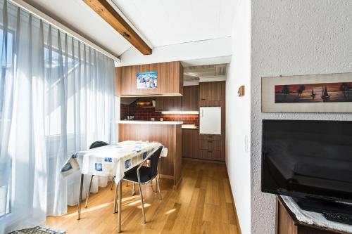 a living room with a table and a kitchen at Appartementhaus-Quadern in Valens