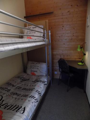 a bedroom with a bunk bed and a desk with a desk at Akropolis odk in Koksijde