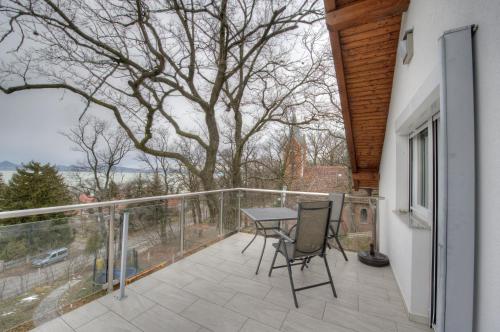 a balcony with a table and chairs and a tree at Hilltop Apartments in Fonyód