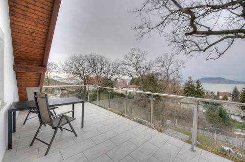 a balcony with a table and chairs and a view at Hilltop Apartments in Fonyód