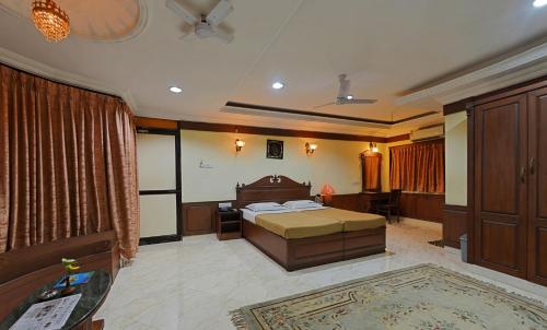 a bedroom with a bed and a desk in it at Hotel Mahabs in Mahabalipuram