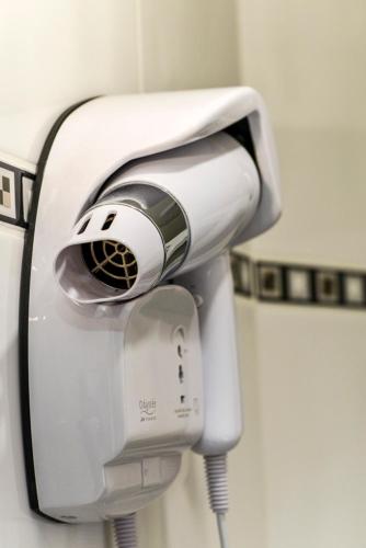a hair dryer hanging on a wall in a bathroom at Hôtel Paris Nord in Paris