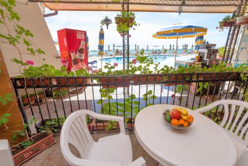 una mesa y sillas con un bol de fruta en el balcón en Apartment complex Mirage of Nessebar, en Nesebar