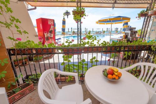a table and chairs with a bowl of fruit on a balcony at Apartment complex Mirage of Nessebar in Nesebar