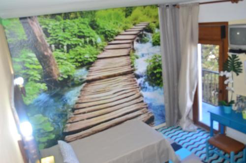 a bedroom with a painting of a wooden bridge at Residencia Santiago Mallorca in Cala Figuera