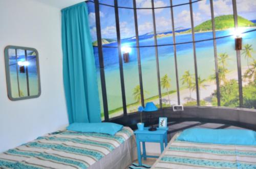 a bedroom with a window with a beach view at Residencia Santiago Mallorca in Cala Figuera