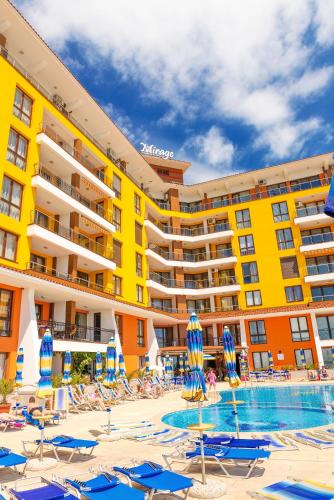 Un hotel con sillas y sombrillas y una piscina. en Apartment complex Mirage of Nessebar, en Nesebar