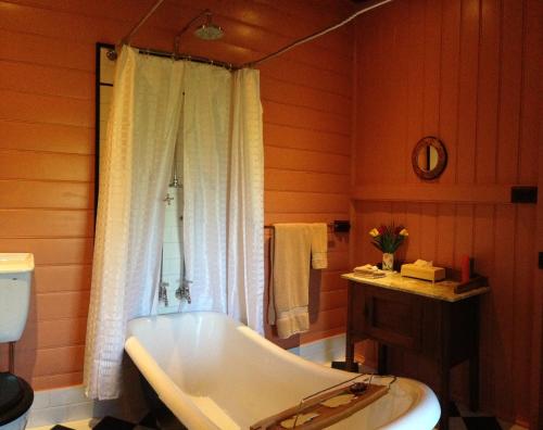 a bathroom with a bath tub and a toilet at Belvoir B&B Cottages in Grafton