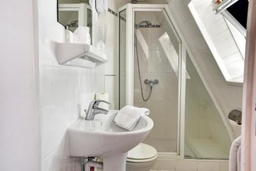 a bathroom with a sink and a shower and a toilet at Hôtel Paris Nord in Paris