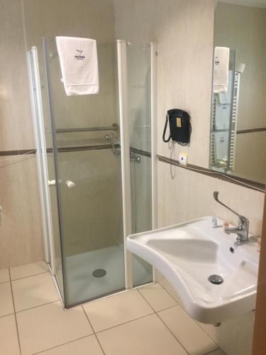 a bathroom with a shower and a sink at Hotel Pombeira in Guarda