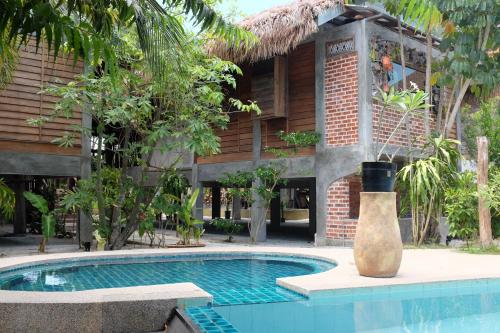 a pool with a pool table in front of a building at Panji Panji Tropical Wooden Home in Pantai Cenang