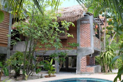 ein Resort mit einem Pool vor einem Gebäude in der Unterkunft Panji Panji Tropical Wooden Home in Pantai Cenang