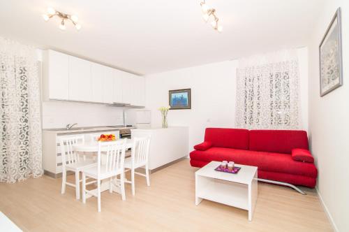 sala de estar con sofá rojo y mesa en Avenue Apartment, en Dubrovnik