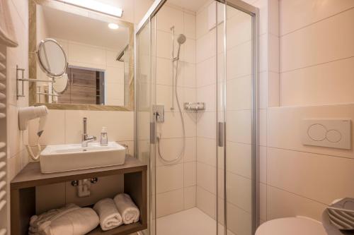 uma casa de banho com um chuveiro e um lavatório. em Hotel Wildauerhof em Walchsee