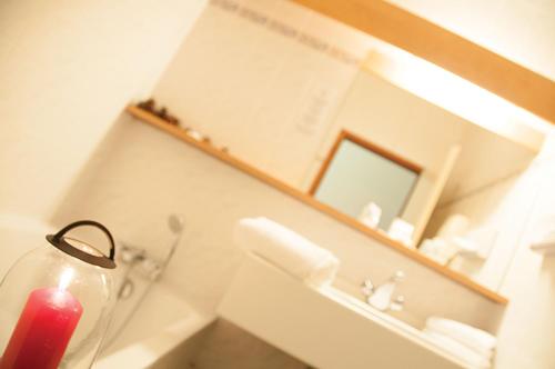 a bathroom with a mirror and a red fire extinguisher at The Originals Boutique, Hôtel La Ferme du Pape, Eguisheim in Eguisheim