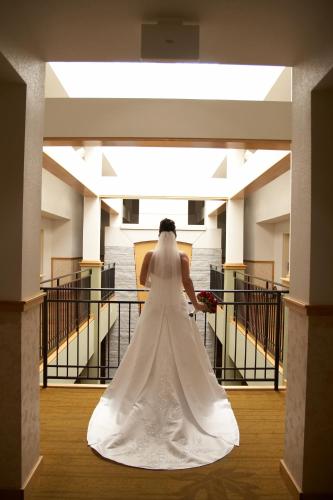 a bride walking down the stairs in her wedding dress at Rocklin Park Hotel, Trademark Collection by Wyndham in Rocklin