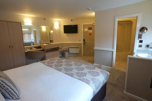 a hotel room with a bed and a bathroom at Damon’s Hotel in Lincoln