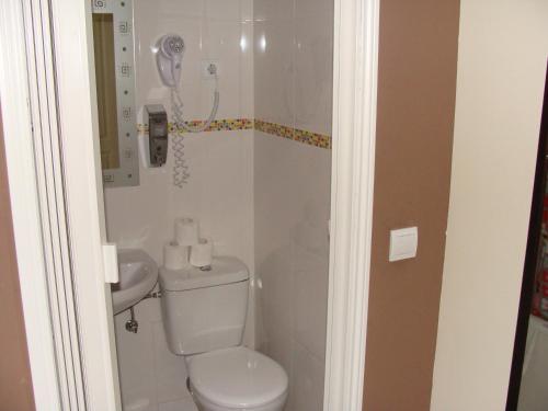 a bathroom with a toilet and a sink at Hostal Oliver in Madrid