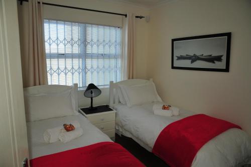 sypialnia z 2 łóżkami obok okna w obiekcie Bradclin Beach Blouberg w mieście Big Bay