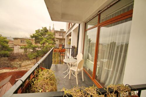 a balcony with a table and chairs on it at Tbilisi View Hotel in Tbilisi City
