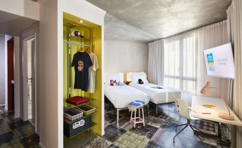une chambre d'hôtel avec deux lits et un bureau dans l'établissement Mama Shelter Marseille, à Marseille