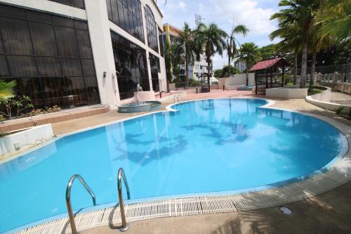 a large blue swimming pool in front of a building at Grand Riverview Hotel in Kota Bharu