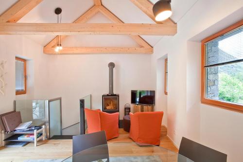 a living room with a glass table and orange chairs at MyVerzasca Resort Casa Rossa in Brione