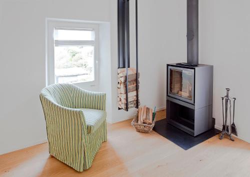 a living room with a chair and a fireplace at MyVerzasca Resort Casa Rossa in Brione