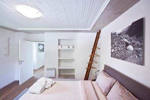 ein Schlafzimmer mit einem Bett und einer Leiter an der Wand in der Unterkunft Casa Rossa in Brione