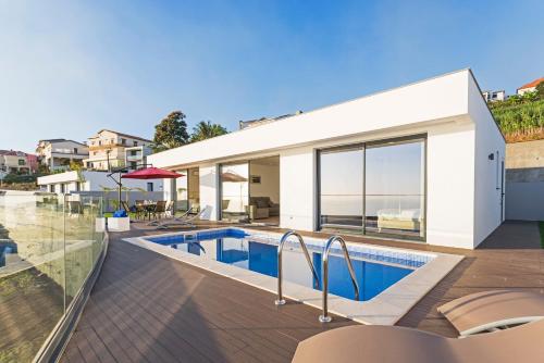 a house with a swimming pool and a patio at Searenity Vacation Home II by An Island Apart in Arco da Calheta