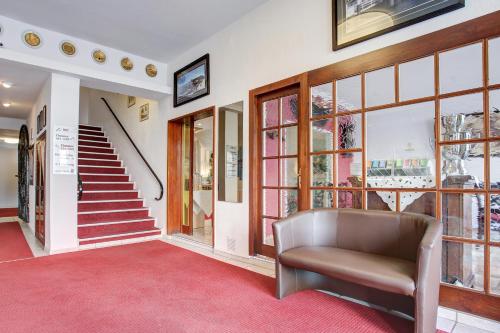 a living room with a couch and a red carpet at Hotel Consul in Kiel
