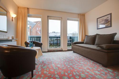 a living room with a couch and two windows at Hotel Consul in Kiel