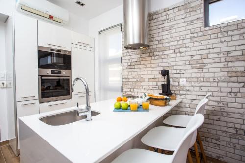 a kitchen with a sink and a brick wall at Yianna's Flat in Faliraki