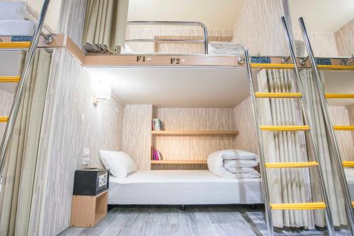 台北市にあるオールド ドア ホステル ＆ バーの小さな客室で、二段ベッド1組、はしごが備わります。