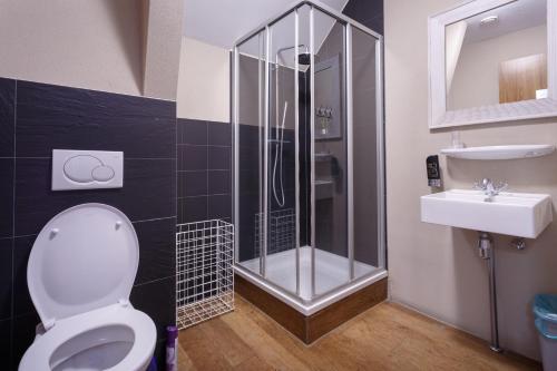 a bathroom with a shower and a toilet and a sink at Hotel Santa Maria in Rotterdam