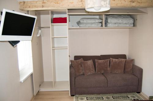 Skruzdynės Apartamentai في نيدا: غرفة معيشة مع أريكة وتلفزيون