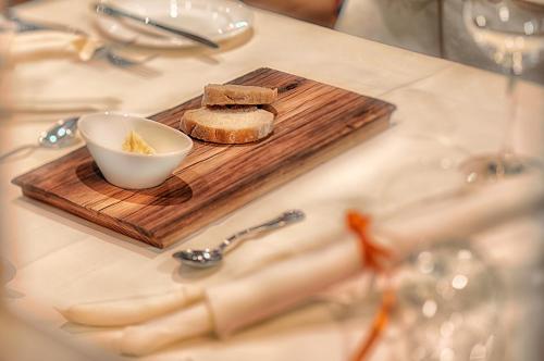 a table with a cutting board with a bowl of bread at Naturhotel MOLIN in San Giovanni in Val Aurina