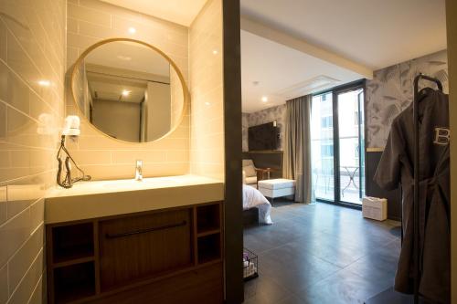 y baño con lavabo y espejo. en Brown-Dot Hotel Choeup en Busan