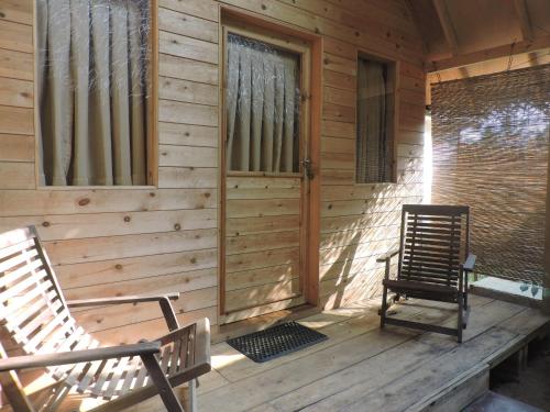 a porch of a wooden cabin with two rocking chairs at Silaa Cabana in Trincomalee