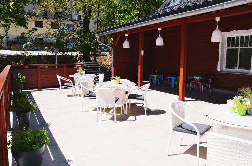 a patio with white tables and chairs and a building at Hotel Willa Odkrywców in Szklarska Poręba