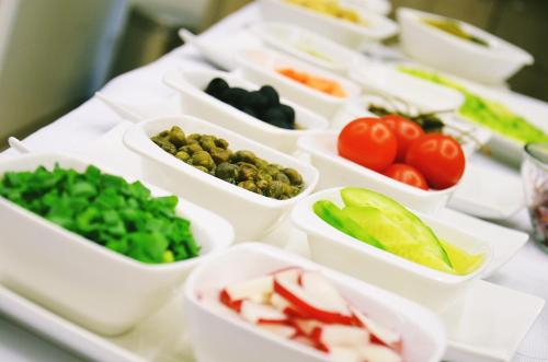 a table topped with white containers filled with vegetables at Hotel Willa Odkrywców in Szklarska Poręba